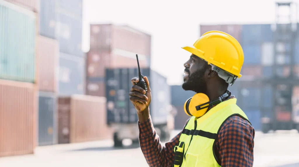 Technicien en communication sur un port maritime.